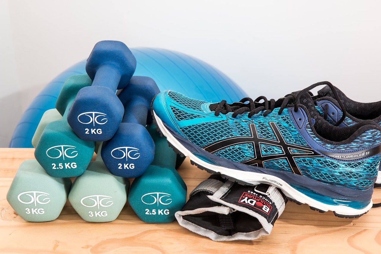 The image features a pair of blue running shoes, small dumbbells, and workout gear, symbolizing fitness and a healthy lifestyle. This visual complements discussions on dietary management and how supplements can enhance physical performance and overall well-being